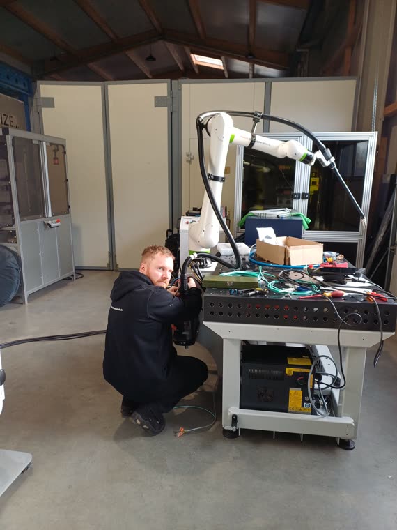 Techniker beim Aufbau der Cobot-Schweißzelle mit FANUC CRX