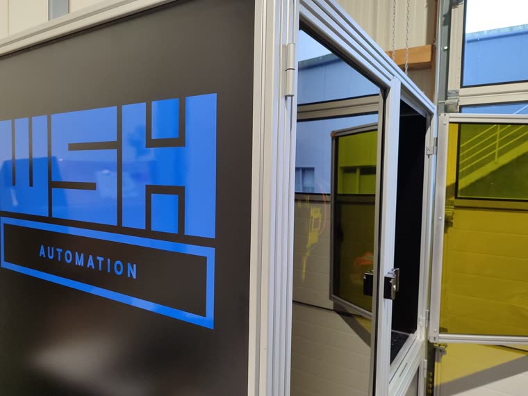 Detail der Kabinentür mit WSH Automation Logo und Laserschutzscheibe