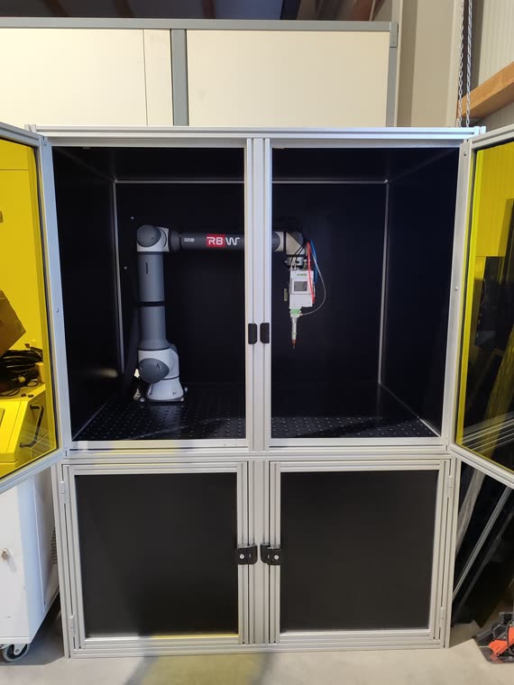 Geöffnete Laserzelle mit RBW Roboter und Laseroptik über dem Spanntisch