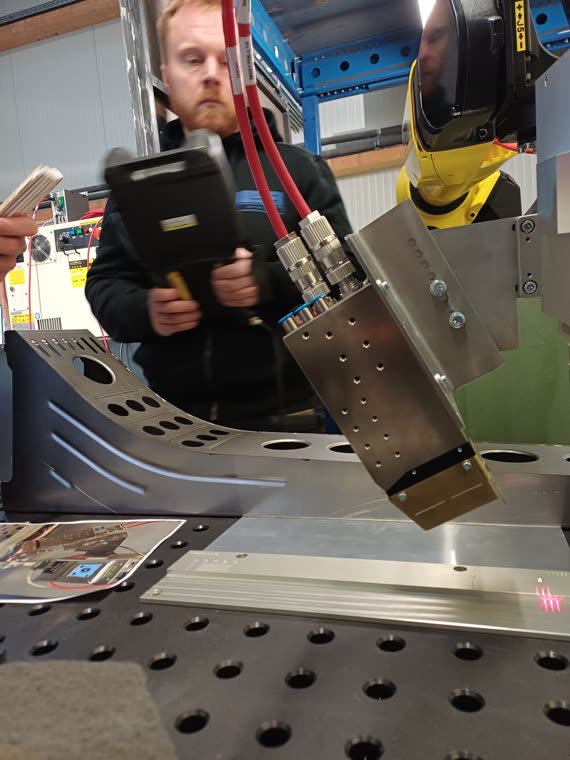 Bediener am Roboter, im Vordergrund die Laseroptik mit der Messlinie