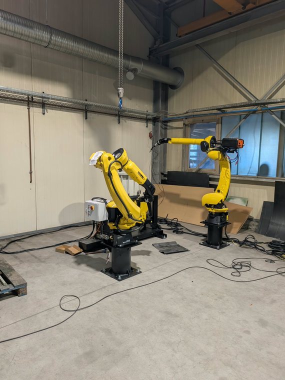 Beide Roboter der Zelle: links der Roboter für Plasmaschneiden und Schleifen, rechts der Schweißroboter