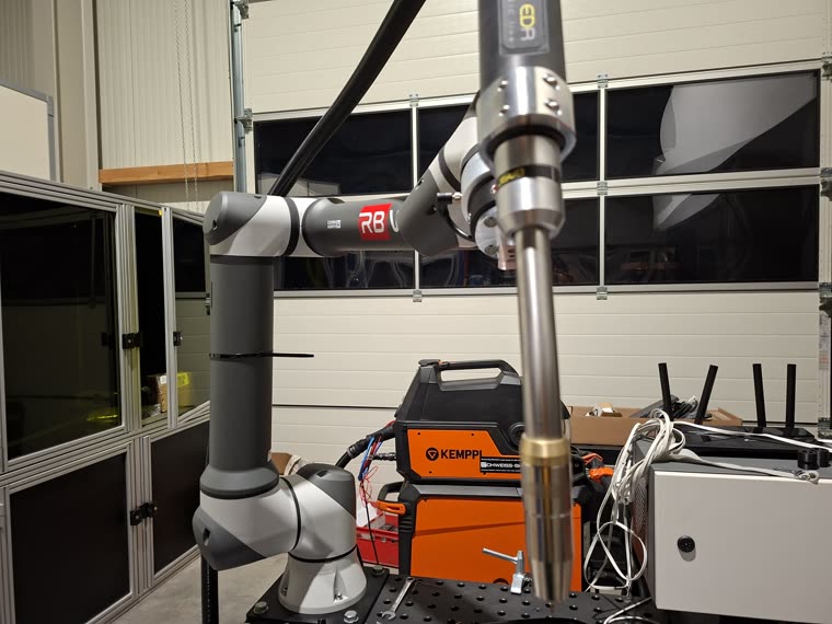 RBW Schweißroboter über dem Spanntisch, dahinter die Kemppi Stromquelle